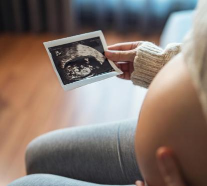 Pregnant woman looking at her ultrasound report.