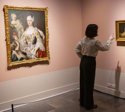 Una dona admirant algunes de les obres presents a l'exposició «La botànica en l'art» a CaixaForum Girona.