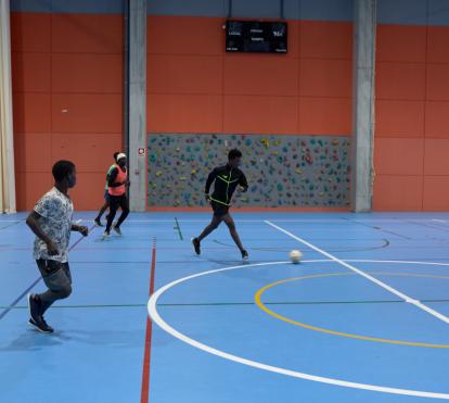 Personas migrantes jugando a fútbol.