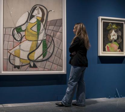 Una visitante observando dos pinturas de la exposición «Arte y naturaleza. Un siglo de biomorfismo».