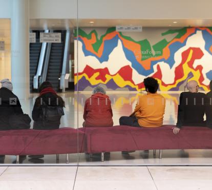 Interior del vestíbulo de CaixaForum Barcelona con visitantes. Al fondo, el mural Splat de Sol Lewitt.