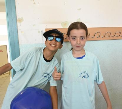 Un nen i una nena beneficiaris del programa CaixaProinfància de la Fundació ”la Caixa” somriuen a càmera.