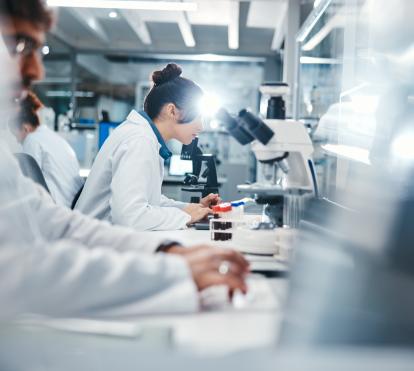 Investigadors observant mostres microscòpiques al laboratori.