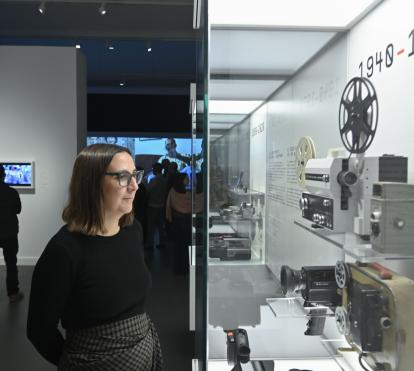 Una mujer observa las diversas cámaras de la muestra Recuerdos. La vida a través del cine doméstico en CaixaForum Barcelona. 