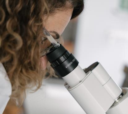 Una investigadora del CaixaResearch Institute observando muestras microscópicas en los laboratorios.