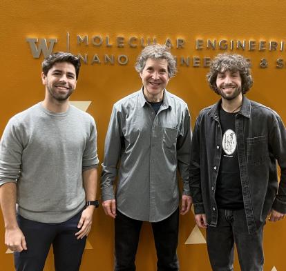Marc Expòsit y Alfredo Quijano posan junto a David Baker, premio nobel de química en 2024.