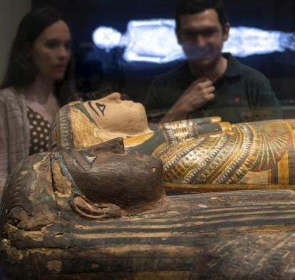 Visitantes observan una de las piezas expuestas en Momias de Egipto, una de las muestras más concurridas en CaixaForum Sevilla.