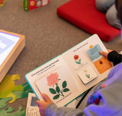 Un niño sentado leyendo atentamente un libro.