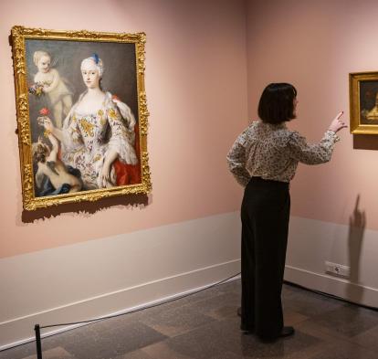 Una mujer admirando las obras presentes en la exposición «La botánica en el arte» en CaixaForum Girona.