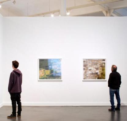 Visitantes observan las obras de una exposición en un centro CaixaForum.