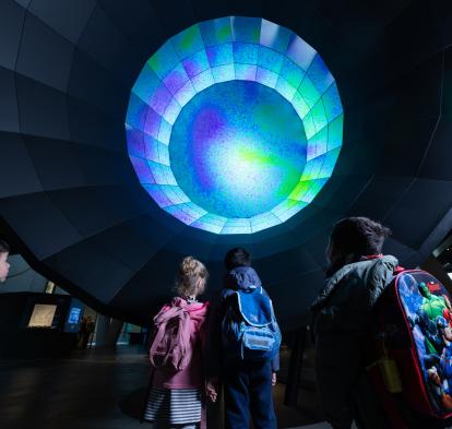 Some boys and girls observe the module on the Big Bang at CosmoCaixa.