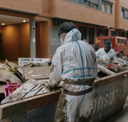 Personas retirando escombros de un garaje.