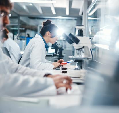Investigadors observant mostres microscòpiques al laboratori.