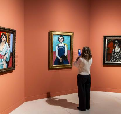 Una mujer fotografía la obra «Marguerite au chat noir», de Henri Matisse, en CaixaForum Madrid.