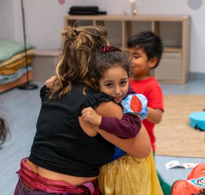 Una nena abraçant a una de les educadores de CaixaProinfància a l'entitat Gaztekulu de Bilbao.