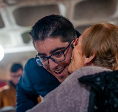 Luisa le da un beso al voluntario que la acompaña, Adrián. 