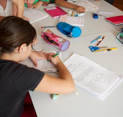 Una niña haciendo deberes en un aula.