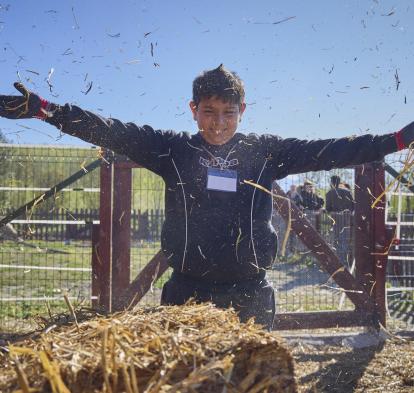 Jose jugando con la paja en un granero.