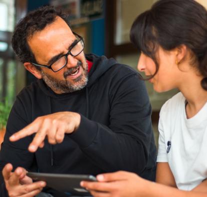 El director del CEIP Ramón y Cajal de Alpartir hablando con una alumna del centro. 