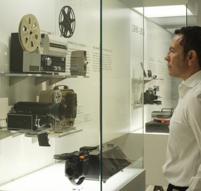 Un visitante observa las cámaras presentes en la exposición «Recuerdos. La vida a través del cine doméstico».