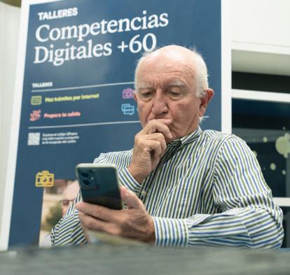 Un señor practica con el móvil durante los talleres Competencias Digitales +60.