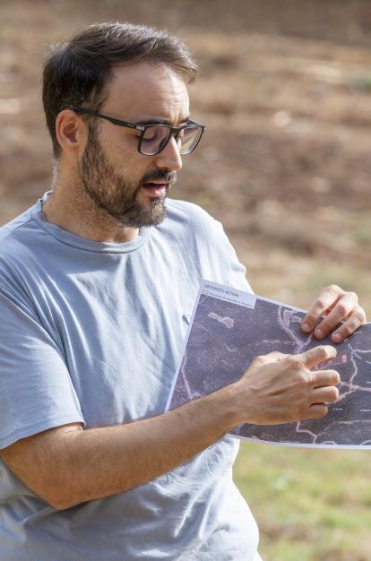 Chema Martín, técnico de AMUFOR, mostrando una foto de la propuesta de bancales a recuperar en Requena.