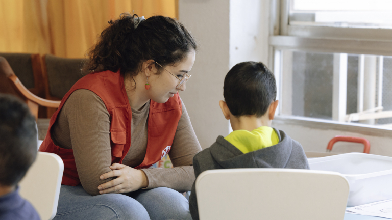 Educadora de CaixaProinfancia atendiendo a niños en la entidad Save The Children.
