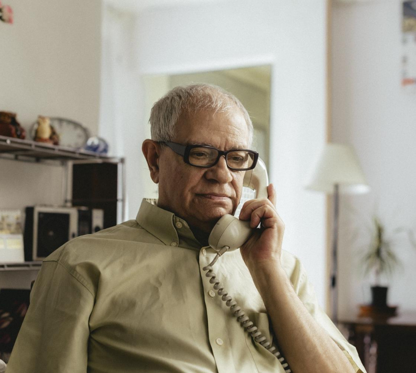An elderly person talking on the phone.