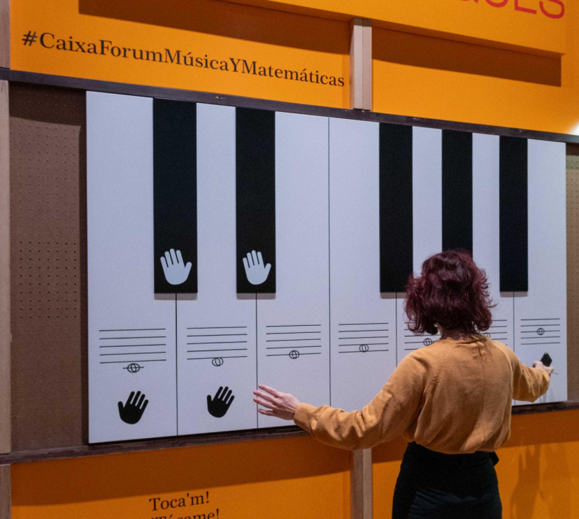 Una visitant interactúa amb el teclat d'entrada de l'exposició «Música i matemàtiques». 