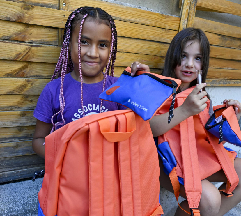 Dos niñas usuarias del programa CaixaProinfancia con su nuevo material escolar. 