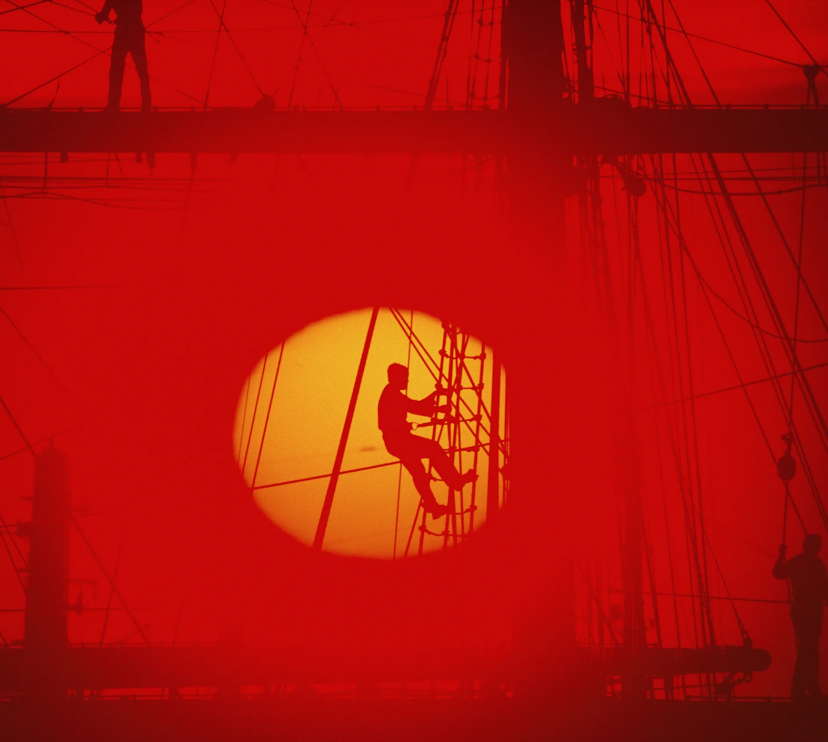 Un marinero trepa por la jarcia de un barco al caer el sol. Buenos Aires, Argentina. 