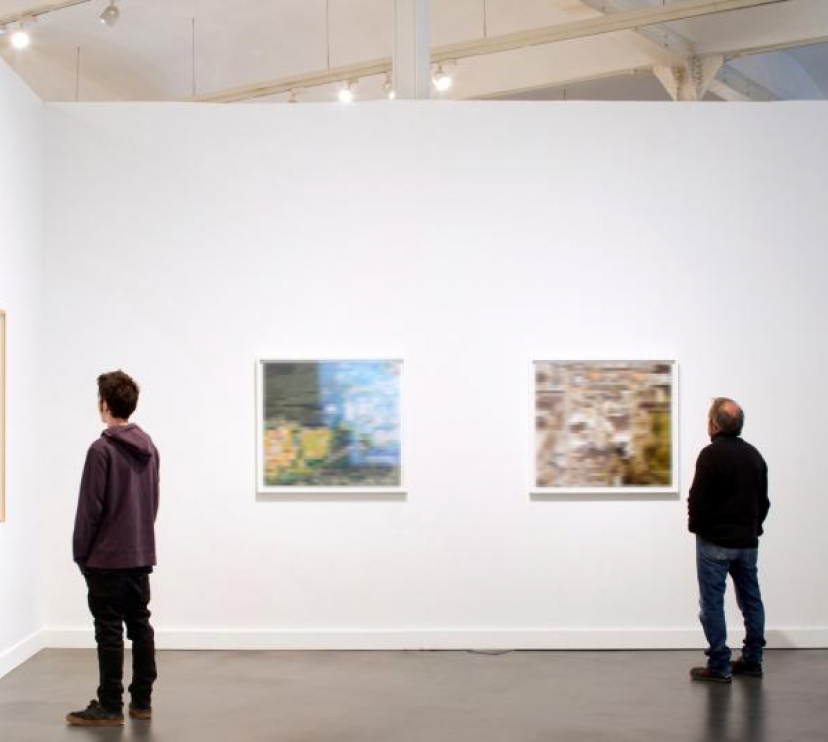 Visitantes observan las obras de una exposición en un centro CaixaForum.