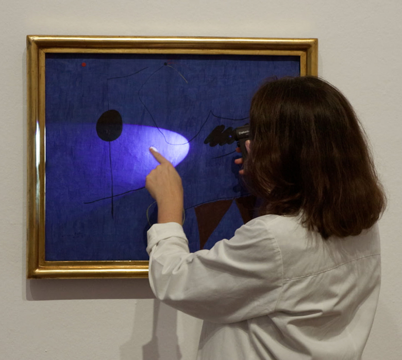 Un membre de l'equip d'investigadors de la Fundació Joan Miró davant d'una de les obres de l'artista.