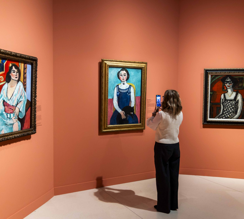 A woman photographs Henri Matisse's "Marguerite au chat noir" at CaixaForum Madrid.