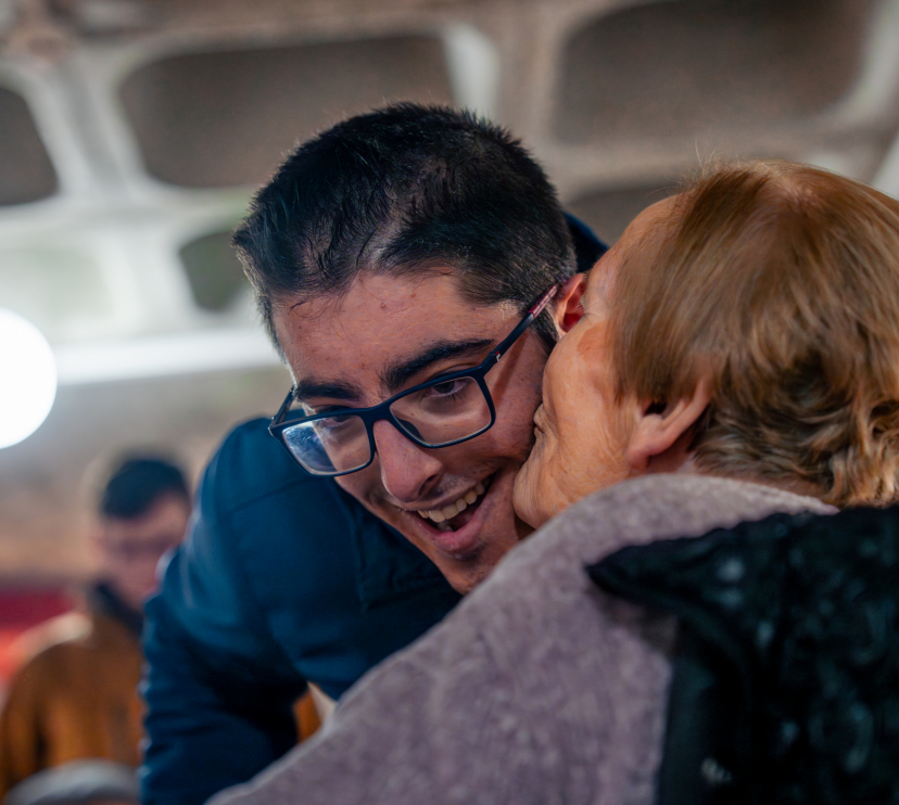 Luisa le da un beso al voluntario que la acompaña, Adrián.