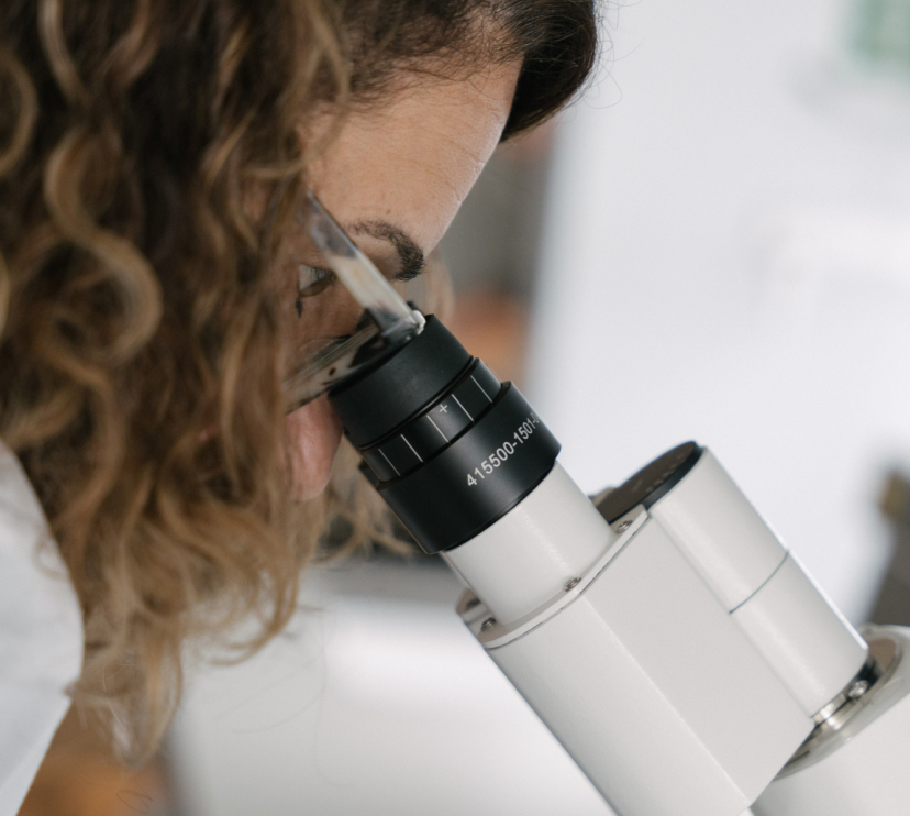 Una investigadora del CaixaResearch Institute observant mostres microscòpiques als laboratoris.