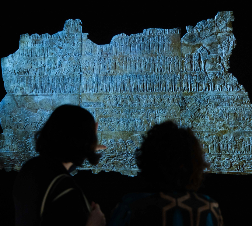 Dos visitantes admirando una de las piezas presentes en la exposición «Asurbanipal» en CaixaForum Madrid.