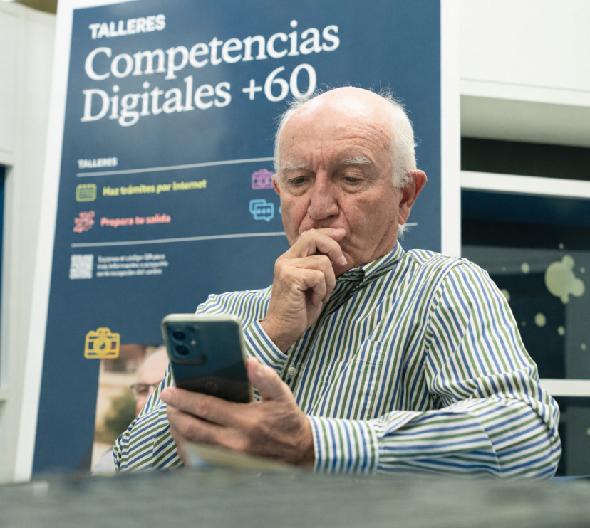 Un señor practica con el móvil durante los talleres Competencias Digitales +60.