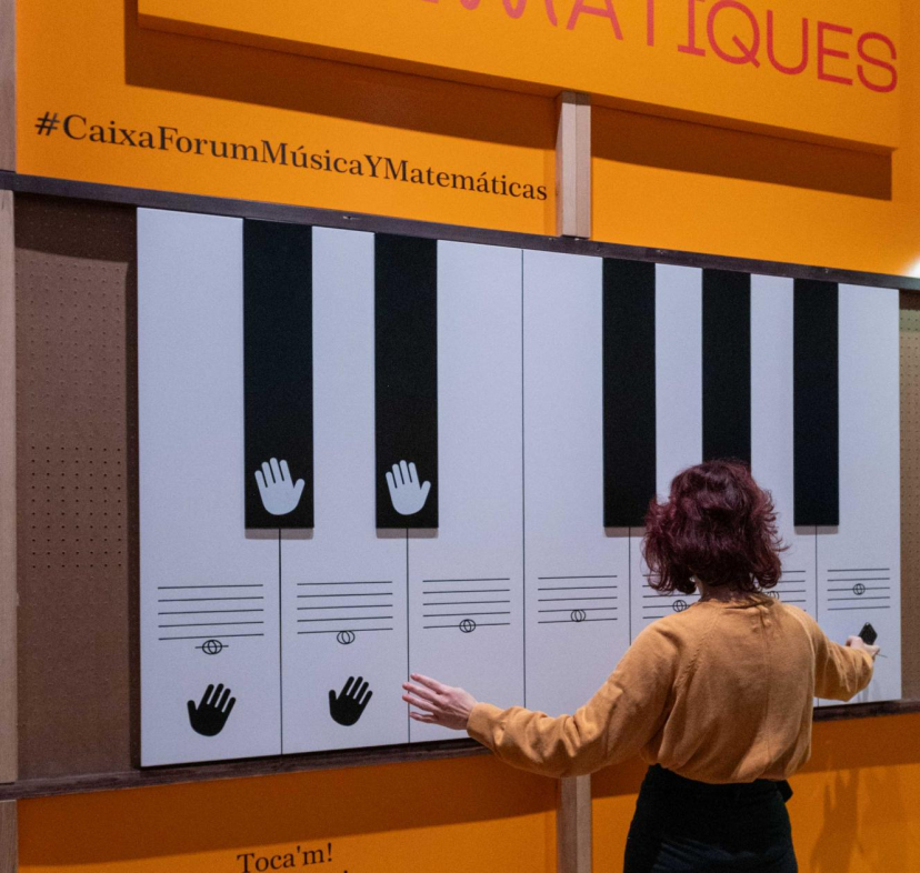 Una visitant interactúa amb el teclat d'entrada de l'exposició «Música i matemàtiques». 
