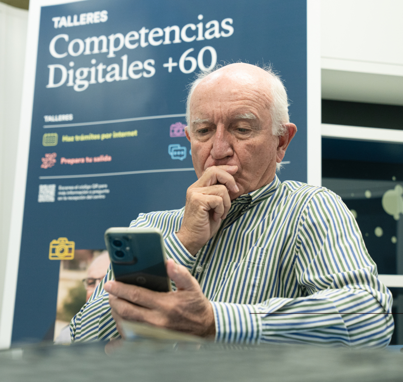 Un señor practica con el móvil durante los talleres Competencias Digitales +60.